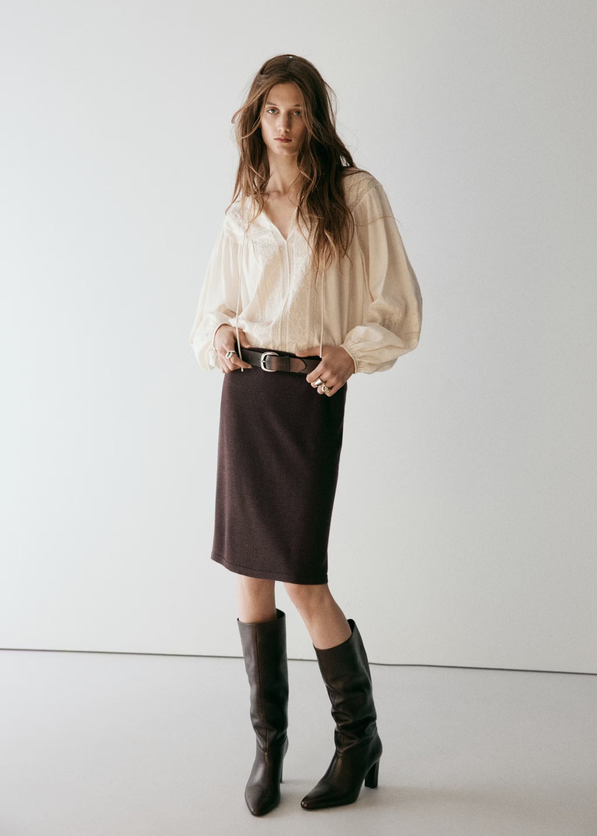 Mango combina la blusa con una falda marrón chocolate y botas altas | Mango