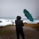 Un hombre ve como el viento le dobla el paraguas en A Coruña