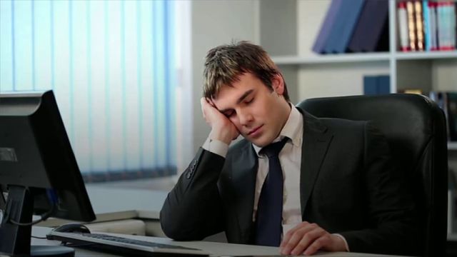 Un empleado está cansado mientras cumple con su jornada laboral