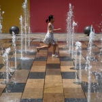 A child plays in a fountain in the Sanlitun area of Beijing, China