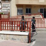 Dos guardias civiles colocan una cinta para impedir el paso en la entrada de las cocheras donde el pasado miércoles murió un miembro de los Tédax