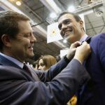 Emiliano García-Page le pone una insignia al secretario general del PSOE, Pedro Sánchez en Fitur.