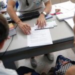 Una doctora, en la consulta con dos pacientes