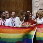 La presidenta de la Junta (c), diputados y miembros de asociaciones LGTBI posan con la bandera arcoiris en el Parlamento