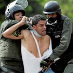 En Venezuela impera la ley del plomo, con un Estado ausente que mira para otro lado e incluso perpetra matanzas. En la imagen, un joven es detenido durante las protestas de julio