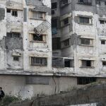 Niños palestinos juegan junto a una edificación destruida durante el conflicto entre Israel y Hamas en 2014, en el barrio Al Shejaeia de Ciudad de Gaza