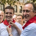 El presidente del PP del País Vasco, Alfonso Alonso (d), pone al presidente de los populares, Pablo Casado, el pañuelo festivo durante la visita de ésta a Vitoria. Foto: Efe