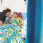 Gladys atiende a su hijo Jahir en la habitación de su casa, en la que pasa la mayor parte del día. No puede moverse, ni comer, ni respirar por sí solo. Su madre es su enfermera particular