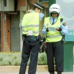 Dos agentes verifican una documentación en una calle de Valencia