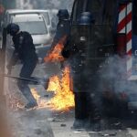 Varios policías huyen tras el lanzamiento de un cóctel mólotov durante la manifestación contra la reforma laboral del Gobierno en París, Francia