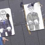 Un participante de la «Marcha de los pueblos libres» lanza su zapato a dibujos de altos cargos nacionales y mundiales