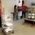 Un operario de la empresa encargada de repartir el material electoral transporta varias urnas para entregar en un colegio electoral, hoy en Barcelona,