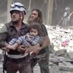 Un miembro de los equipos de rescate traslada a una niña
