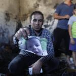 Uno de los familiares enseña una foto del pequeño de 18 meses fallecido