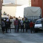 Un grupo de vecinos se agolpan frente a la vivienda en la localidad almeriense de Adra, donde la Guardia Civil ha localizado los cadáveres de un hombre de 62 años y de una mujer marroquí de 23