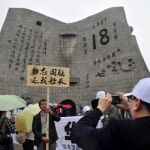 Un hombre sujeta un letrero con el mensaje "No olvides la humillación nacional, devuelve nuestro barco capitán"ante el museo del 18 de Septiembre en Shenyang (China)