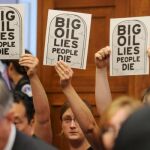 Unas personas sostienen unos carteles en los que se lee "La gran petrolera miente y la gente muere"durante la reunión del subcomité de Energía, Comercio y Medio Ambiente de la Cámara de Representantes