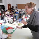 Imagen de una maestra corrigiendo a un niño durante una clase en un aula