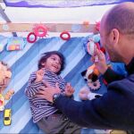 El pequeño Osman juega con uno de los bomberos españoles que montan guardia las 24 horas del día para que no pierda la vida