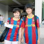 Las dos aficionadas chinas muestran su entrada para el partido de hoy a las puertas del estadio olímpico de Pekín