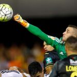 El portero del Valencia, Jaume Domenech (d), despeja un balón