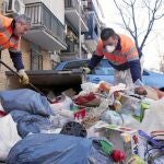 Varios operarios de Lipasam recogen la basura acumulada durante la huelga