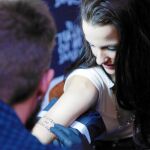 Amanda, ayer, mientras le tatuaban en el brazo un mensaje discriminatorio; después, fue corregido