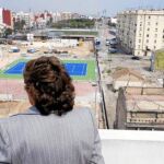 Rita Barberá, en una de sus últimas visitas al barrio. Al fondo a la derecha, el edificio de pescadores