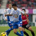 El defensa del Deportivo de La Coruña Aythami Artiles (c) con el balón ante el centrocampista francés del RCD Mallorca Michael Pereira (d)
