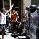 Un manifestante increpa a los antidisturbios de los Mossos d'Esquadra, durante los incidentes producidos hoy en el barrio de Gràcia de Barcelona.