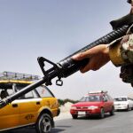 Un oficial de seguridad afgano vigila las carreteras de Kabul, tras la noticia de la muerte del mulá Omar