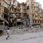 Un hombre pasa delante de edificio dañado por bombardeos en Aleppo