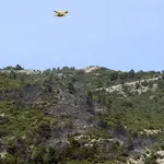 Un hidroavión sobrevuela las inmediaciones del lugar en el que se ha producido un accidente de una avioneta de la empresa Avialsa que trabajaba en la extinción de un incendio entre La Sènia (Tarragona) y Tinença de Benifassà (Castellón)