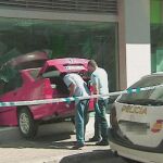El BMW rojo quedó empotrado en la luna de la sucursal de Caja Madrid de Avenida de América