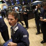 Un corredor de la Bolsa de Nueva York atiende a los monitores