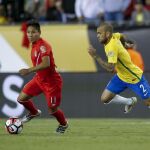 Raúl Ruidiaz (i) de Perú disputa un balón con Dani Alves (