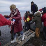Los voluntarios ayudan a grupo de refugiados llegados a las costas griegas desde Turquía.