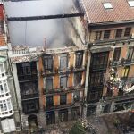 Un grupo de bomberos trata de entrar para rescate el cuerpo del compañero fallecido.