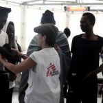Un inmigrante recibe ropa de un tripulante del Aquarius