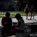 Varios turistas se protegen del sol durante la ola de calor en el madrileño parque de El Retiro / Foto: Efe