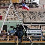 Una perforadora llega al taller junto al que están los mineros chilenos