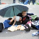 A LA INTEMPERIE. Varios refugiados, ayer, en la frontera entre Austria y Hungría, cerca de Heliligenkreuz, ayer
