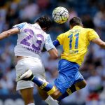 El defensa del Málaga Miguel Torres (i) y el centrocampista de la Unión Deportiva las Palmas Momo Figueroa (d), saltan por el balón durante el partido.