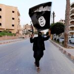 Un miembro del Estado Islámico, con la bandera del grupo terrorista