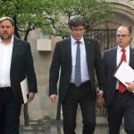 El presidente de la Generalitat, Carles Puigdemont (c), junto al vicepresidente, Oriol Junqueras (i), y el conseller de Presidencia, Jordi Turull.