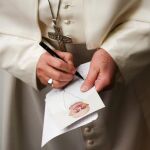 El Papa firma una imagen suya durante la audiencia