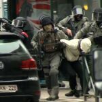 Oficiales de policía escoltan a un detenido en Molenbeek