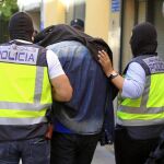 Efectivos de la policía trasladan a uno de los detenidos