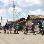 Durante el entrenamiento, Mike Carlos Otieno, de 13 años, capitán del equipo, encabeza la fila de niños que patinan en sincronía entre las chabolas de chapa.