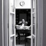 Camilo José Cela, entre libros y folios, posa en la mesa de trabajo de su estudio
